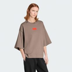 KOSZULKA Z KRÓTKIM RĘKAWEM I GRAFIKĄ AUDI REVOLUT F1 TEAM ELEVATED. Brązowe t-shirty damskie Adidas, xs, bez wzorów, z bawełny, bez kołnierzyka. Za 239.00 zł.