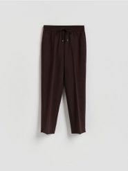 Spodnie z kantem - ciemnobrązowy. Brązowe spodnie materiałowe damskie Reserved, bez wzorów, z tkaniny. Za 119.99 zł.