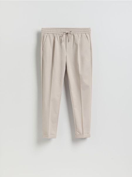 Spodnie regular z włóknem bambusowym - beżowy. Brązowe spodnie materiałowe męskie Reserved, bez wzorów, z dzianiny. Za 129.99 zł.