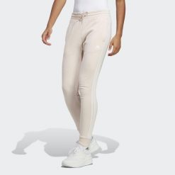 Spodnie damskie adidas Essentials 3-Stripes French Terry Cuffed. Białe spodnie materiałowe damskie Adidas, bez wzorów, sportowe. Za 182.00 zł.
