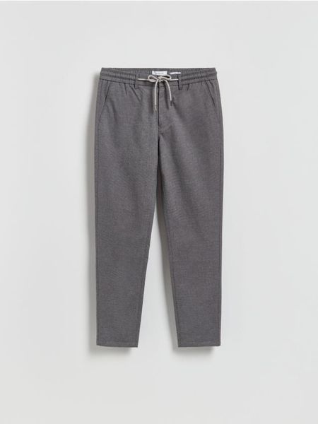 Spodnie carrot z wiązaniem - ciemnoszary. Szare spodnie materiałowe męskie Reserved, bez wzorów, z tkaniny. Za 149.99 zł.
