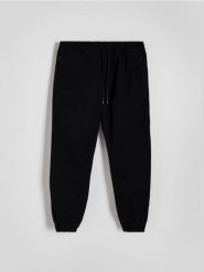 Spodnie jogger slim - czarny. Czarne spodnie materiałowe męskie Reserved, bez wzorów, z bawełny. Za 129.99 zł.
