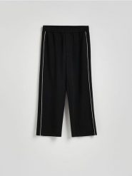 Spodnie loose fit - czarny. Czarne spodnie materiałowe męskie Reserved, bez wzorów, z dzianiny. W wyprzedaży za 59.99 zł.