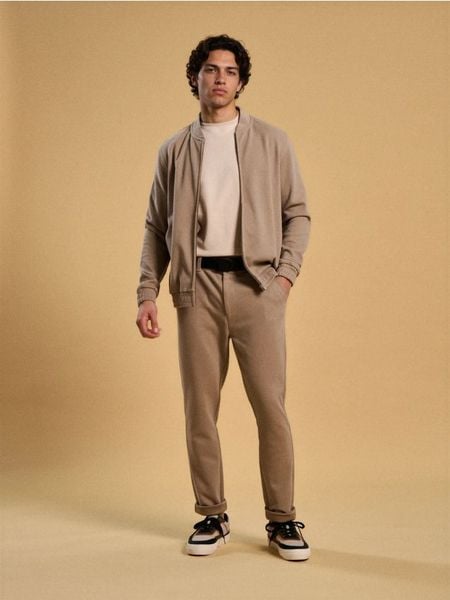 Spodnie slim - beżowy. Brązowe spodnie materiałowe męskie Sinsay, bez wzorów. Za 69.99 zł.