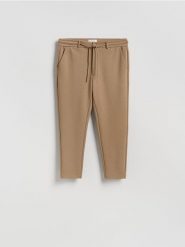 Spodnie chino slim fit - beżowy. Brązowe spodnie materiałowe męskie Reserved, bez wzorów, z bawełny. W wyprzedaży za 69.99 zł.