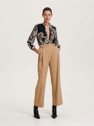 Bawełniane spodnie - bursztynowy. Pomarańczowe spodnie materiałowe damskie Reserved, bez wzorów, z bawełny. W wyprzedaży za 45.99 zł.