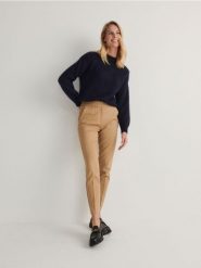 Spodnie z kantem - beżowy. Brązowe spodnie materiałowe damskie Reserved, bez wzorów, z bawełny, klasyczne. W wyprzedaży za 65.99 zł.