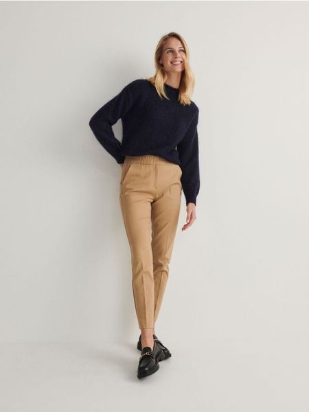 Spodnie z kantem - beżowy. Brązowe spodnie materiałowe damskie Reserved, bez wzorów, z bawełny, klasyczne. W wyprzedaży za 65.99 zł.