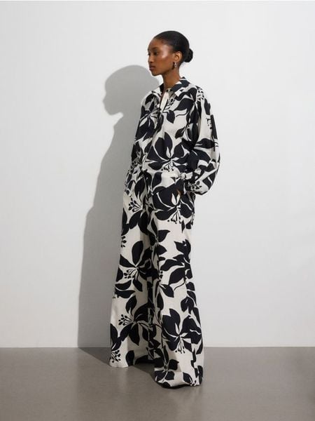 Wzorzyste spodnie palazzo - wielobarwny. Spodnie materiałowe damskie Reserved, bez wzorów, z bawełny. W wyprzedaży za 89.99 zł.