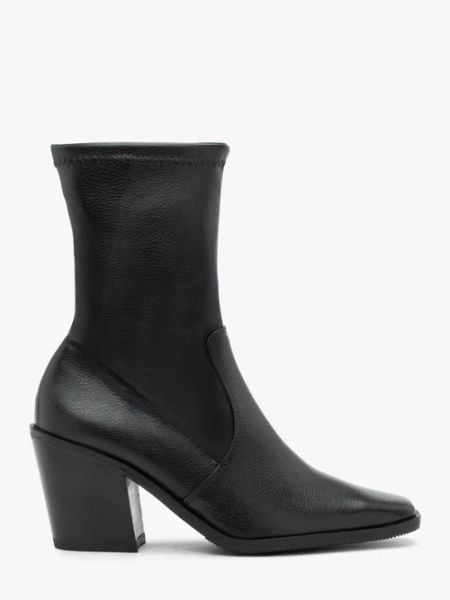 Czarne wyższe botki z elastyczną cholewką. Czarne botki damskie Ryłko, ze skóry, klasyczne, bez obcasa, na słupku, bez zapięcia. W wyprzedaży za 299.99 zł.