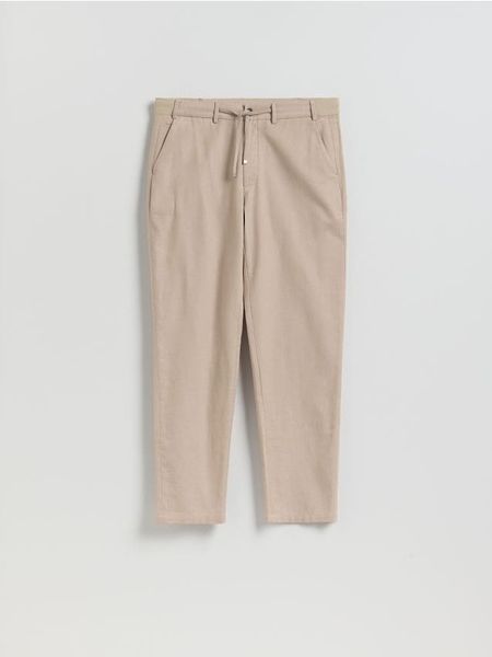 Spodnie chino regular fit - beżowy. Brązowe spodnie materiałowe męskie Reserved, bez wzorów, z tkaniny. Za 159.99 zł.