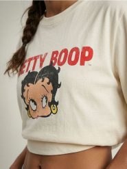 Bawełniana koszulka z nadrukiem Betty Boop - żółty. Żółte t-shirty damskie Sinsay, l, bez wzorów, z bawełny, bez kołnierzyka. Za 39.99 zł.