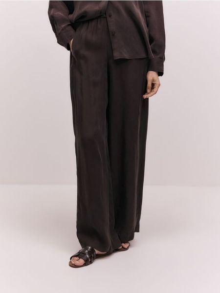 Spodnie z cupro - ciemnobrązowy. Brązowe spodnie materiałowe damskie Reserved, bez wzorów, z tkaniny. Za 239.99 zł.