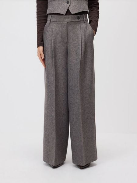 Spodnie z zakładkami - brązowy. Brązowe spodnie materiałowe damskie Reserved, bez wzorów, z tkaniny. W wyprzedaży za 99.99 zł.