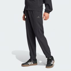 Spodnie dresowe Algeria. Czarne spodnie dresowe męskie Adidas, bez wzorów, z dresówki. W wyprzedaży za 230.30 zł.