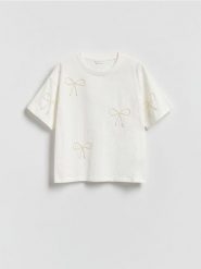 Bawełniany t-shirt z aplikacjami - złamana biel. Koszulki dziewczęce Reserved, z aplikacjami, z bawełny, bez ramiączek. Za 45.99 zł.