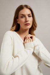 Sweter z dekoltem w serek i długimi rękawami kremowy. Białe swetry klasyczne damskie MOODO, l, z poliamidu, bez kołnierzyka. W wyprzedaży za 51.99 zł.