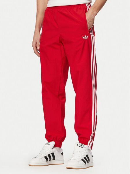Adidas Spodnie dresowe Firebird Woven KE1369 Czerwony Regular Fit. Czerwone spodnie dresowe męskie Adidas, bez wzorów, z dresówki. Za 299.99 zł.