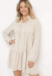 Beżowa Rozkloszowana Sukienka z Falbanką Uxaria. Brązowe sukienki damskie Born2be, na lato, uniwersalny, z aplikacjami, eleganckie, bez kołnierzyka, bez ramiączek, rozkloszowane. Za 99.99 zł.