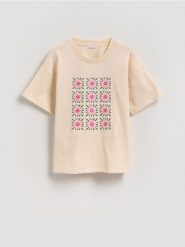 Luźny t-shirt z haftem - kremowy. Białe koszulki dziewczęce Reserved, bez wzorów, z bawełny, bez ramiączek. Za 45.99 zł.