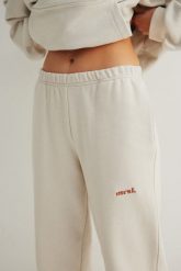 Spodnie typu jogger z HAFTEM w kolorze IVORY - NEVIS-L. Brązowe spodnie materiałowe damskie Marsala, bez wzorów, z bawełny, eleganckie. Za 279.90 zł.
