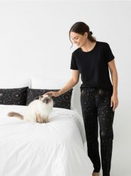 Spodnie piżamowe z szeroką nogawką i motywem kotów i gwiazd - czarny. Czarne piżamy damskie Sinsay, l, bez wzorów, bez ramiączek. Za 29.99 zł.