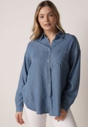 Niebieska Koszula Jeansowa z Bawełną Ozdobiona Kieszonką Koreti. Niebieskie koszule damskie Born2be, bez wzorów, z bawełny, eleganckie, bez kołnierzyka, bez ramiączek. Za 109.99 zł.