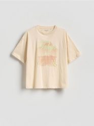 Luźny t-shirt z nadrukiem - kremowy. Białe koszulki dziewczęce Reserved, bez wzorów, z bawełny, bez ramiączek. Za 35.99 zł.