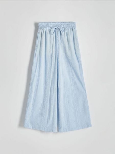 Spodnie culotte - jasnoniebieski. Niebieskie spodnie materiałowe damskie Reserved, bez wzorów, z bawełny. W wyprzedaży za 45.99 zł.