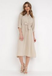 Beżowa Sukienka Rheniolea. Brązowe sukienki damskie Born2be, m, bez wzorów, eleganckie, bez kołnierzyka, bez ramiączek, midi, kopertowe. Za 89.99 zł.