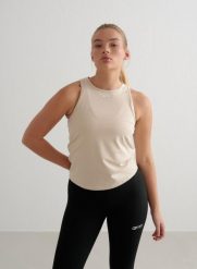 Damski top treningowy ultramiękki, szybkoschnący Soft Basic beżowy. Białe topy sportowe damskie Aim'n, xs, bez wzorów, z dzianiny, bez ramiączek. Za 127.00 zł.