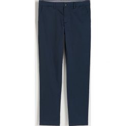 Spodnie chino slim fit - granatowy. Niebieskie spodnie materiałowe męskie Reserved, bez wzorów, z bawełny. W wyprzedaży za 119.99 zł.