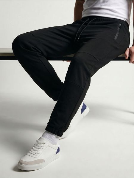 Spodnie dresowe slim fit z domieszką wiskozy - czarny. Czarne spodnie sportowe męskie Sinsay, z dresówki. Za 69.99 zł.