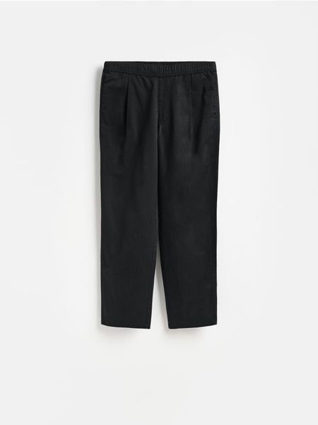 Spodnie loose carrot - czarny. Czarne spodnie materiałowe męskie Reserved, bez wzorów, z bawełny. Za 129.99 zł.