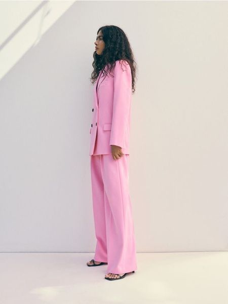 Spodnie z kantem - intensywny róż. Czerwone spodnie materiałowe damskie Reserved, bez wzorów, z tkaniny. W wyprzedaży za 79.99 zł.