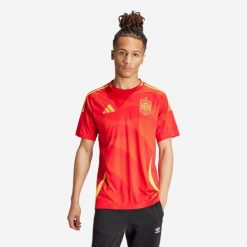 Koszulka piłkarska drużyny Hiszpanii ADIDAS domowa. Czerwone bluzki damskie Adidas, l, bez wzorów, sportowe, bez kołnierzyka, bez ramiączek. W wyprzedaży za 279.99 zł.