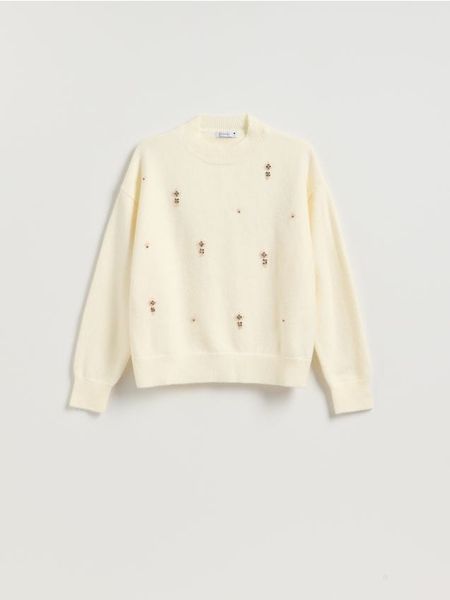 Sweter z ozdobnymi aplikacjami - kremowy. Białe swetry klasyczne damskie Reserved, l, z dzianiny, bez kołnierzyka. Za 139.99 zł.