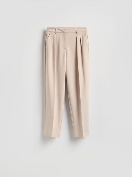 Spodnie z kantem - beżowy. Brązowe spodnie materiałowe damskie Reserved, bez wzorów, z tkaniny. Za 129.99 zł.