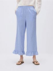 Bawełniane spodnie z falbanką - jasnoniebieski. Niebieskie spodnie materiałowe damskie Reserved, bez wzorów, z bawełny. Za 99.99 zł.