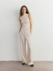 Luźne spodnie - kremowy. Białe spodnie materiałowe damskie Reserved, bez wzorów, z dzianiny. Za 119.99 zł.