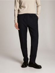 Spodnie slim fit z dodatkiem wełny - granatowy. Niebieskie spodnie materiałowe męskie Reserved, bez wzorów, z tkaniny. Za 249.99 zł.
