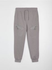 Spodnie jogger z kieszeniami na zamek i przeszyciami - szary. Szare spodnie materiałowe męskie Sinsay, bez wzorów, sportowe. Za 79.99 zł.