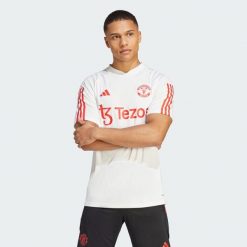 Koszulka piłkarska męska Adidas Manchester United Tiro 23. Białe t-shirty sportowe męskie Adidas, l, z materiału, bez ramiączek, do piłki nożnej. Za 246.35 zł.