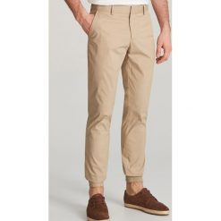 Spodnie jogger - Beżowy. Brązowe spodnie materiałowe męskie Reserved, bez wzorów. W wyprzedaży za 39.99 zł.