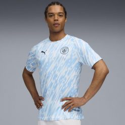 Koszulka piłkarska Puma Manchester City 25/26 przedmeczowa. Bluzki damskie Puma, l, bez wzorów, z materiału, sportowe, bez kołnierzyka, bez ramiączek. Za 339.99 zł.