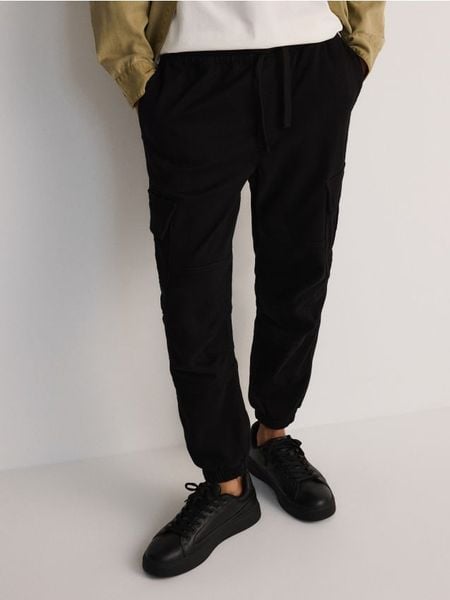 Spodnie cargo jogger - czarny. Czarne spodnie materiałowe męskie Reserved, bez wzorów, z bawełny. W wyprzedaży za 69.99 zł.