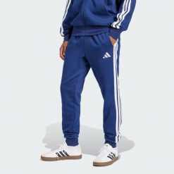 Spodnie Essentials 3-Stripes Fleece. Białe spodnie sportowe męskie Adidas, z materiału. Za 171.99 zł.