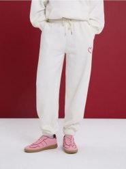 Polarowe spodnie jogger - kremowy. Białe spodnie materiałowe damskie Sinsay, bez wzorów, z polaru. Za 39.99 zł.