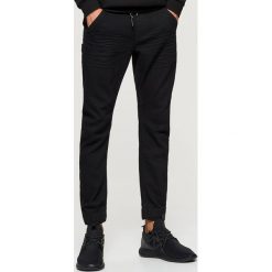 Jeansy SLIM JOGGER - Czarny. Czarne jeansy męskie Cropp. Za 129.99 zł.