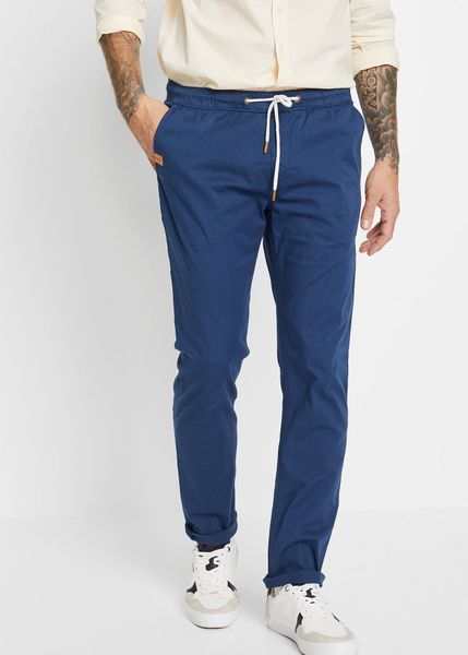 Spodnie z gumką w talii, ze stretchem, slim fit, prosta nogawka. Niebieskie spodnie materiałowe męskie bonprix, bez wzorów, ze skóry. Za 149.99 zł.